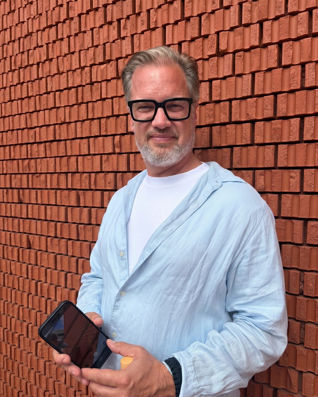 Oliver Thylmann in front of a red brick wall